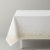 Styled image of a white tablecloth with gold dot border draped over table