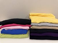 Stack of folded knit tops showing colour variety