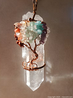 Front view of wire-wrapped clear quartz pendant showing gemstone chips and copper wire detail