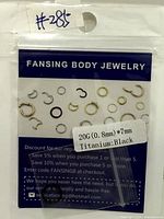 Front of sealed Fansing Body Jewelry package showing assorted ring graphics and size label 20G (0.8 mm) ×7 mm Titanium: Black