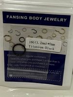 Front of sealed package showing black titanium hoop and size label 16G (1.2 mm) × 9 mm