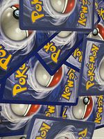 Stack of Pokémon card backs showing standard blue Poké Ball design