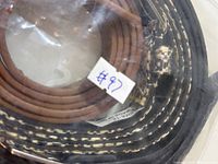 Three rolled belts displaying buckle styles and colours