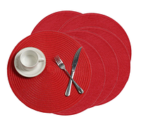 Six red round braided placemats with cup, fork and knife for scale