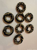 All eight napkin rings arranged flat for full view of design and quantity