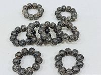 All eight metal bead rings laid flat on surface