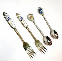 front view of two enamel-handled forks and two crest spoons