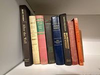 Shelf view of all nine books showing spines