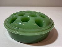 side view of jadeite flower frog showing domed shape and green color