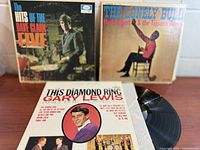 Front view of all three album jackets with one record partially visible