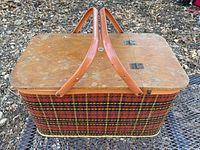 Front and top of picnic basket showing plaid wicker body, wood lid, handles