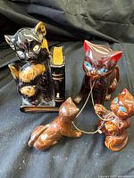 Group shot of all four ceramic cat figurines including pen holder and chained set