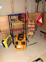 Overall lot: ladder toss frame, yellow toy car, wooden chair with flags, Swingball case