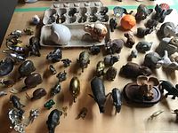 Wide view of table with entire assortment of elephant figurines and egg carton of miniatures