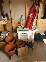 Group shot showing rolling cart, camp chair bag, wrought iron brace, terracotta pots and metal stands