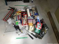 Overview of entire lot showing caulking gun, paint tray, rollers, brushes, sandpaper, steel wool, sponges, tools, bulbs, caulk