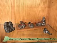 All three soapstone sculptures in display cabinet