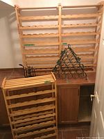 Overall view showing three wood racks, green metal pyramid rack, black wrought iron rack on cabinet