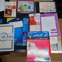 All items laid out showing each pack of paper, labels, banner paper, certificates, and cards