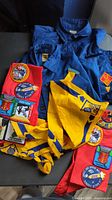 Overall lot showing blue shirt, yellow neckerchief, red neckerchief with patches
