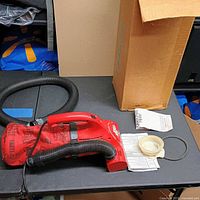 Vacuum, hose, belt, paperwork and box on table
