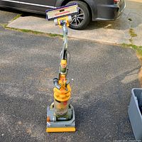 Full view of Dyson DC14 upright vacuum standing on driveway
