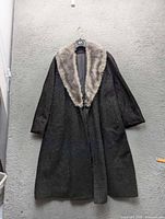 Front view of dark charcoal wool coat with light grey fur collar