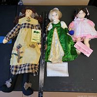 Overview of three dolls with ruler for scale