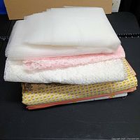 Side view of stacked fabrics showing textures and prints