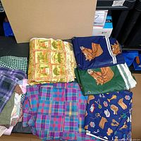 Stack of folded fabrics showing variety of prints and colors