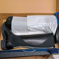 Boot laying in opened box showing side profile, sole and tissue wrap