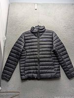 Front view of black Patagonia down jacket hanging