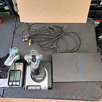 Top view showing PS2 console, Saitek joystick, Saitek throttle and AV cable
