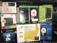 Overview of boxed Seagate, WD hard drives and Intel Pentium CPU in crate