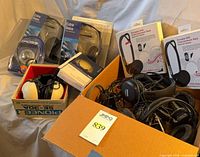 Overall lot showing sealed Koss Extra Bass packages, Koss DVD Entertainment Pack boxes, Pioneer boxed headset and loose headphones