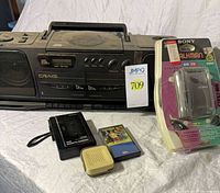 Group shot of all five items including Craig boombox, sealed Sony Walkman, Sanyo recorder, Archer amplifier, and cassette tape