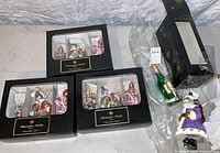 Three boxed Nutcracker Suite sets and two loose packaged ornaments on table