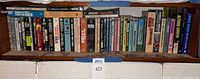 Shelf containing approximately 40 science-fiction books, spines outward