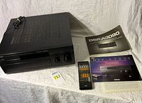 Front view of amplifier with remote and manuals