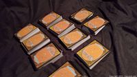 Twelve stacks of Magic card backs on dark fabric