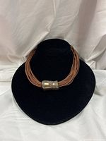 Full necklace on display bust showing pendant position and multi-strand leather design