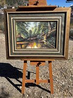 Full view of framed painting on easel