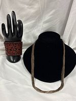 Necklace on display bust and leather cuff bracelet on hand form