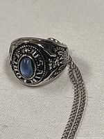Front view of sterling U.S. Air Force ring pendant showing blue stone and partial chain