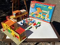 Overall view of depot building, figures, vehicles and original box