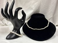 Necklace displayed on velvet bust and bracelet on hand display