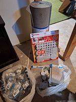 Lot overview showing shelf liner roll, Richelieu felt pads pack, bag of Amerock hardware, loose felt pads