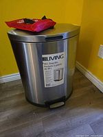 Stainless steel step bin with fire blanket pouch rested on top