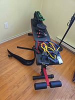 Overall view of bench with stacked weight plates, resistance bands and belt