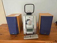 Front view of full system with main unit, two speakers, remote, antenna visible